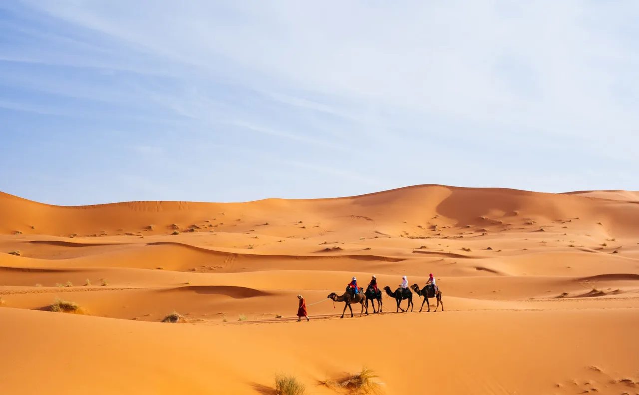 People riding camels in the Sahara Desert near Merzouga